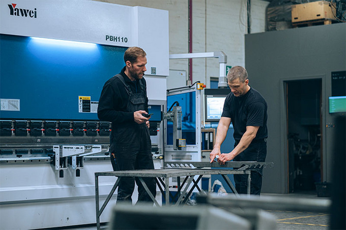 To mænd der arbejder i Øgendahls produktion ved bukker maskinen